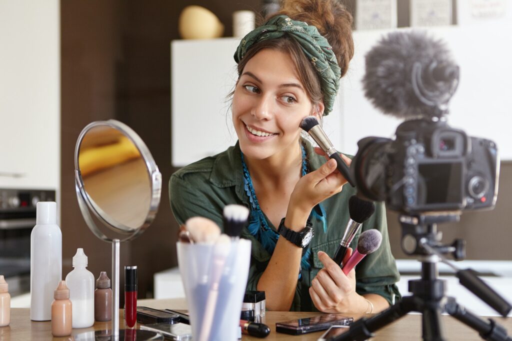 Indoor shot of young beuatiful female making beauty vlog episode about high quality cosmetics for wo